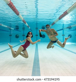 Couple Celebrating With A Bottle Of Champagne Inside Swimming Pool.