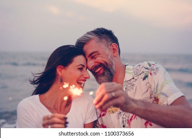 Couple Celebrating With Sparklers At The Beach