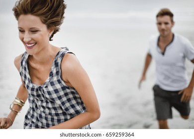 Couple chasing each other on beach