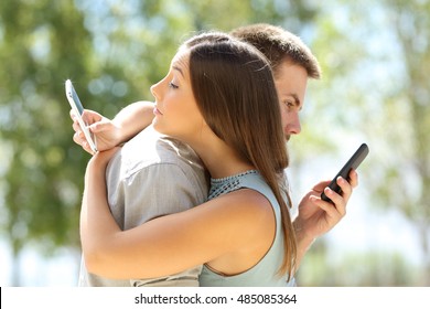 Couple of cheaters hugging and texting everyone on their smart phones