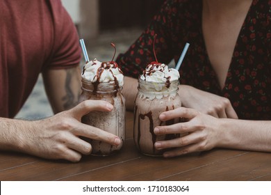 Couple with chocolate milkshake, cherry and cream - Powered by Shutterstock