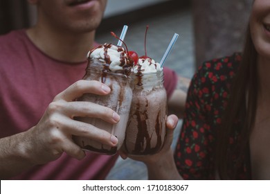 Couple with chocolate milkshake, cherry and cream - Powered by Shutterstock