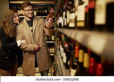 Couple Choosing Alcohol In A Liquor Store 