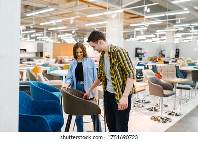 Couple Choosing Bar Chair In Furniture Store