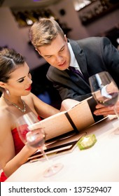 Couple choosing meal from the menu card in restaurant