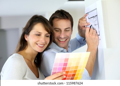 Couple Choosing Paint Colour For Their New Home