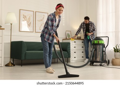 Couple Cleaning Up In Living Room Together