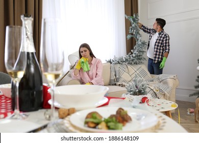 Couple Cleaning Messy Room After New Year Party