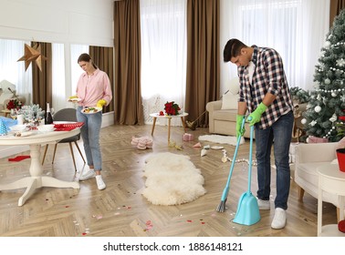 Couple Cleaning Messy Room After New Year Party