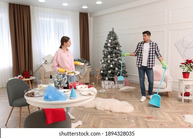 Couple Cleaning Messy Room After New Year Party