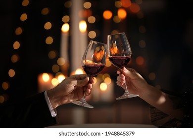 Couple clinking glasses at Valentine's day dinner in restaurant, closeup - Powered by Shutterstock