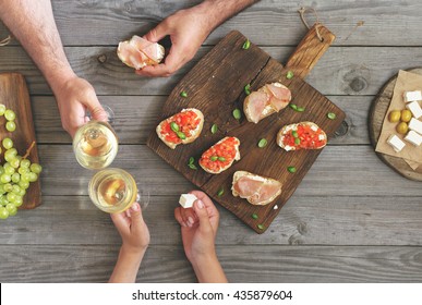 Couple clinking glasses with white wine, top view - Powered by Shutterstock