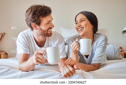 Couple coffee, interracial smile and relax on bed in house, smile for love marriage and funny communication in bedroom of home. Man and woman happy with tea drink and comic conversation in morning - Powered by Shutterstock