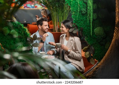 Couple with coffee and macarons spending time together in cafe - Powered by Shutterstock