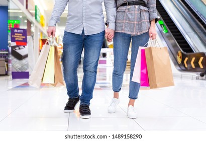 Couple with colourful shopping bags walking in mall, making purchases together, crop