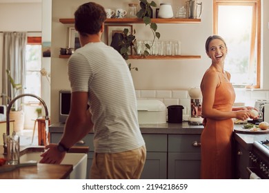 Couple cooking food, household cleaning or food preparation together in their kitchen at home. Laughing, bonding and caring husband and wife helping each other prepare supper, lunch or meal - Shutterstock ID 2194218659