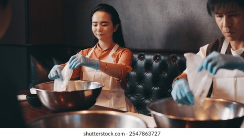 Couple, cooking and together on date in restaurant for culinary skills, learning and meal prep in bowl. Japanese people, bonding and raw ingredients in cafe for ramen noodles class and experience - Powered by Shutterstock