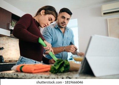 Couple Cooking Together Watching Tutorial For Recipe