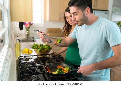 Couple Cooks Dinner Together On Stove Hot Food Blows Cool Air Before Biting Tasting