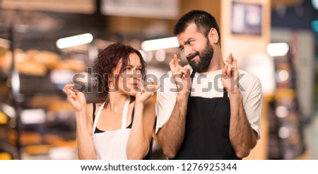 Couple of cooks with fingers crossing and wishing the best