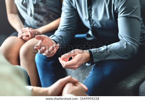 Couple counseling or therapy session. Man\
talking about problems in the family. Husband and wife meeting\
their psychiatrist. Discussion with marriage counselor, mediator or\
relationship\
psychologist.