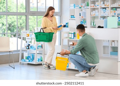 Couple of customers with shopping baskets choosing medications at pharmacy - Powered by Shutterstock