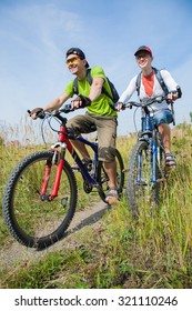 Couple of cyclists riding bicycles in nature park