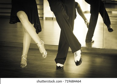 Couple of dancers dancing lindy hop in bright gold and black and white shoes