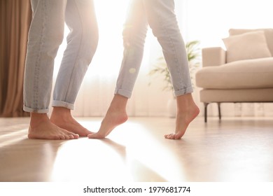 Couple dancing barefoot at home, closeup. Floor heating system - Shutterstock ID 1979681774