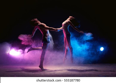 Couple dancing on the scene in cloud of powder