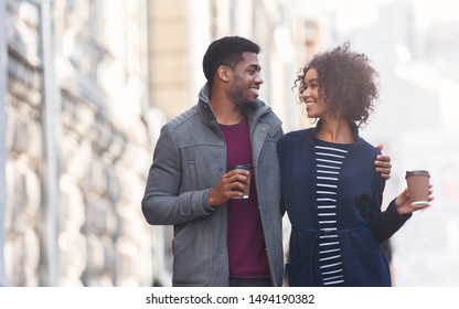 Couple date. Black man and woman drinking coffee outdoors, walking in the city, copy space - Powered by Shutterstock