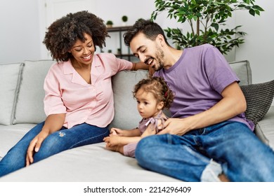 Couple And Daughter Smiling Confident Sitting On Sofa At Home