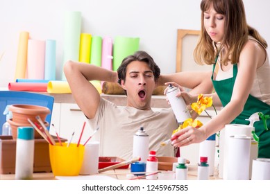 Couple decorating pots in workshop during class