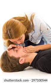 Couple Demonstrating First Aid Techniques With Woman About To Perform Mouth Resuscitation.