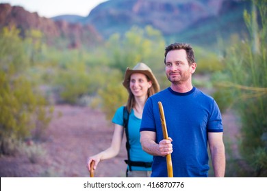 Couple desert hiking near mountains in the American Southwest - Powered by Shutterstock