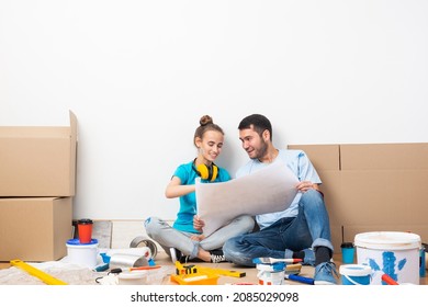 Couple Discussing Home Redesign Ideas. Man And Woman Together Planning New Home Interior Design. Cardboard Boxes, Painting Tools And Materials On Floor. House Remodeling And Architectural Renovation.