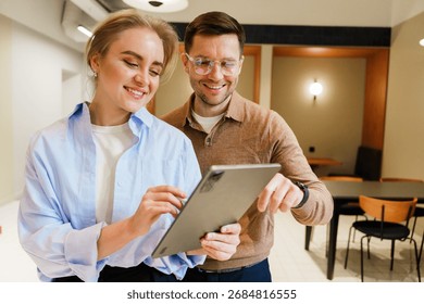 Couple discussing ideas while using a tablet in a modern cafe setting