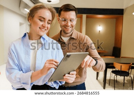 Couple discussing ideas while using a tablet in a modern cafe setting