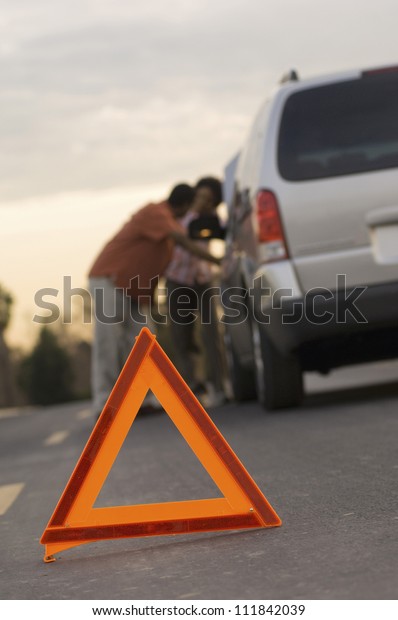 Couple\
in discussion with warning triangle in\
foreground