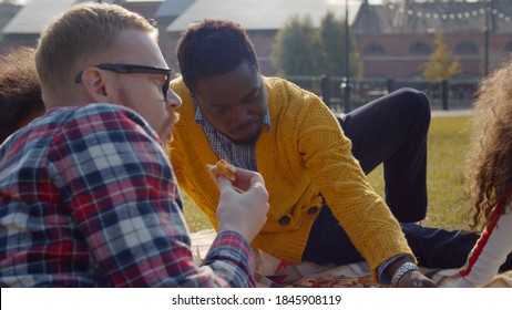 Couple Of Diverse Gays Having Fun In Park With Adopted Little Daughters. Multiracial Family With Preschool Kids Relaxing On Blanket With Food Outdoors Enjoying Weekend