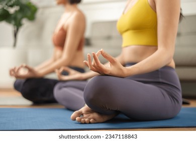 Couple diversity sporty people practicing .Asian active woman friend doing Yoga Pilates workout together at home. - Powered by Shutterstock