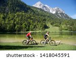 Couple and a dog biking in front of a beautiful sea in bavaria