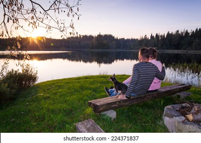 Couple With Dog Enjoy The Late Summer Sunset