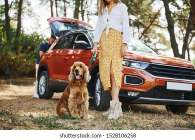 Couple With Dog Have Weekend Outdoors In The Forest With Car.