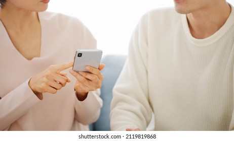 A Couple Doing Research On Their Smartphone.