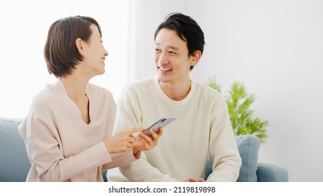 A Couple Doing Research On Their Smartphone.