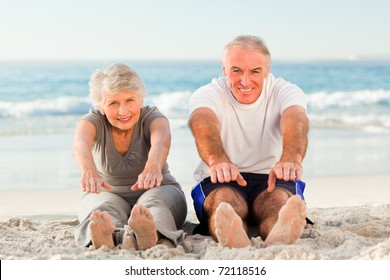 Couple doing their streches at the beach - Powered by Shutterstock