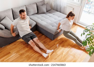 Couple Doing Triceps Dips On Living Room Couch While Working Out Together At Home