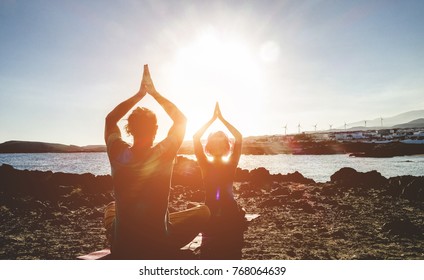 Couple Doing Yoga Outdoor At Sunrise In Nature - Woman And Man Meditating Together At Morning Time - Concept Of Fitness Exercise For Healthy Lifestyle And Positive Mind - Main Focus On Man Silhouette