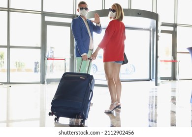 Couple Dressed In Luxury Suits With Suitcase Wave Goodbye Before Flying On Vacation